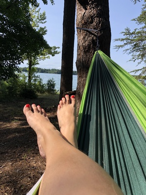 pretty tiny feet with red toenails in a green hammock